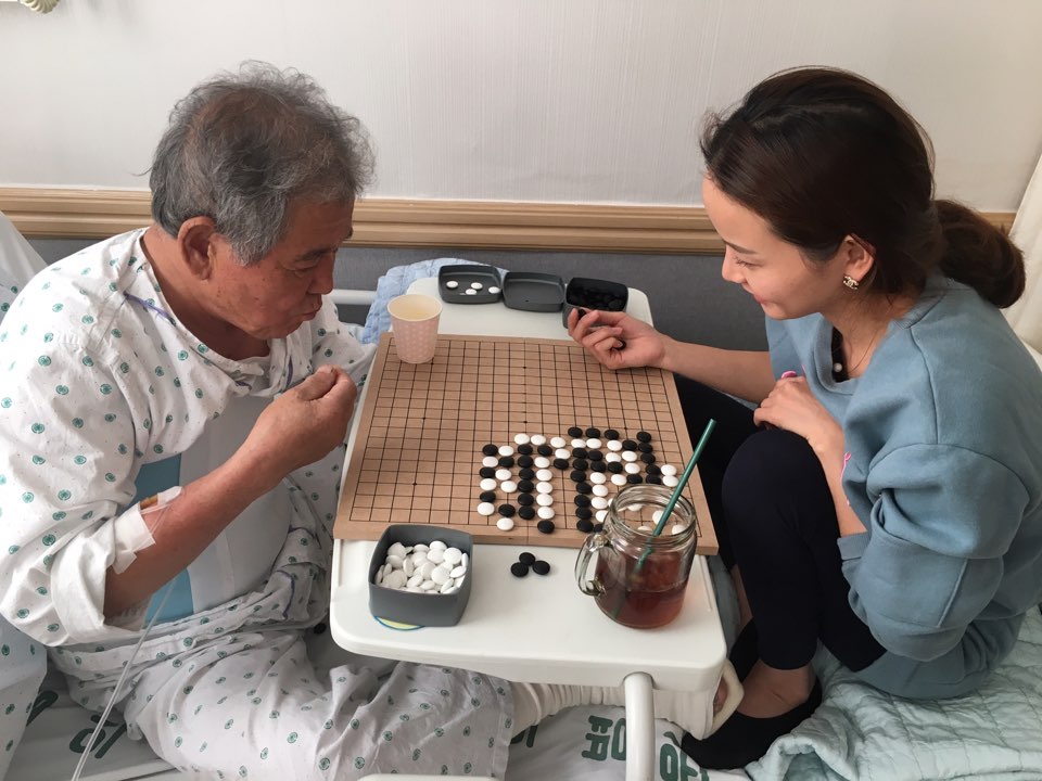 A daughter and her father sharing a game together