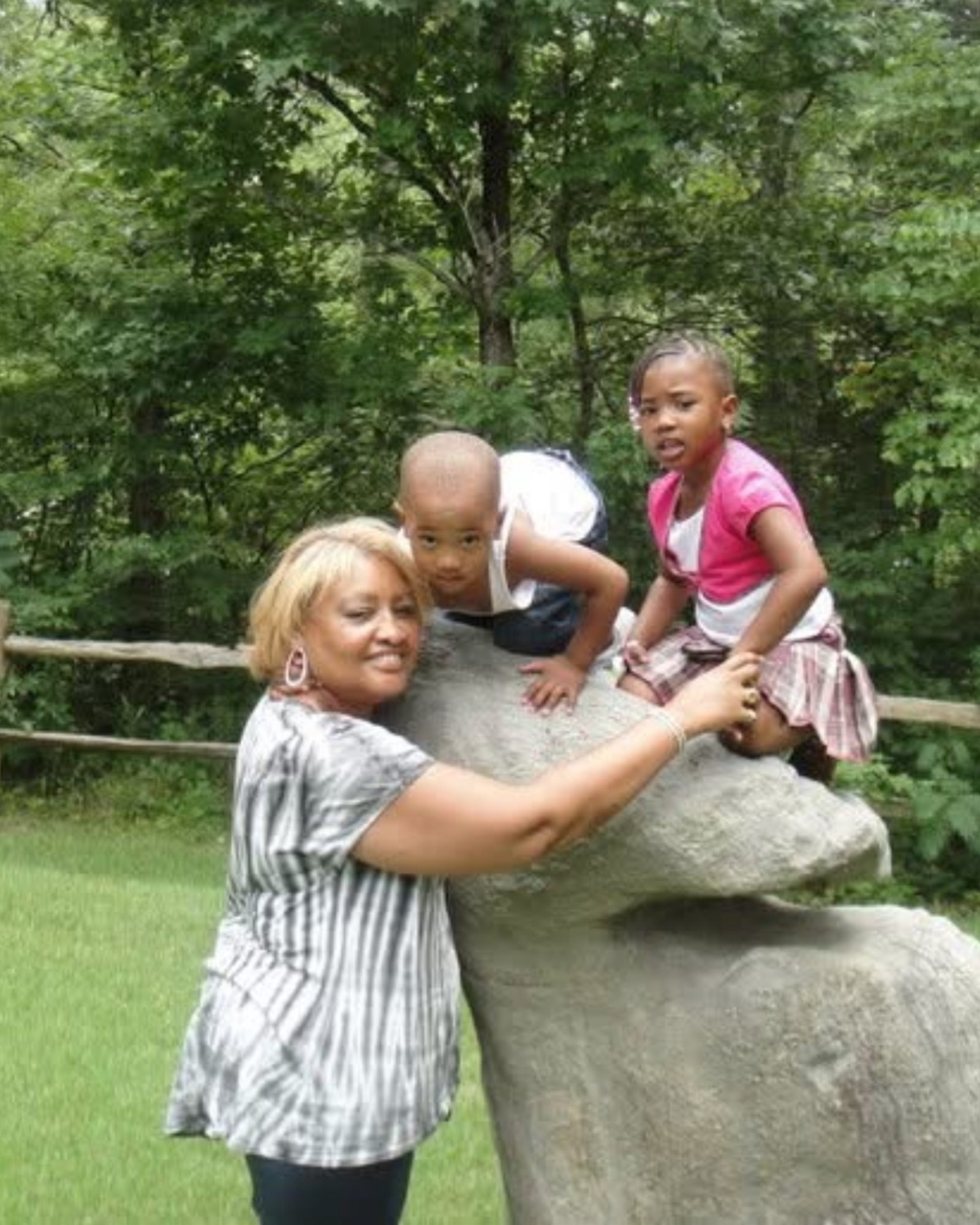 A grandmother helping her grandchildren climb