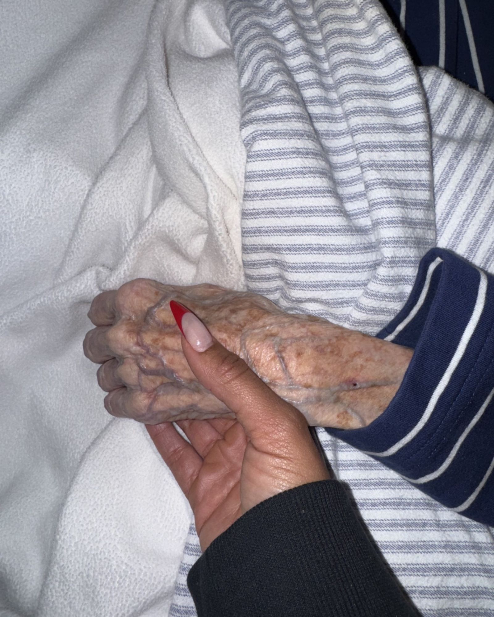 A hand held in comfort during a grandmother's final hours